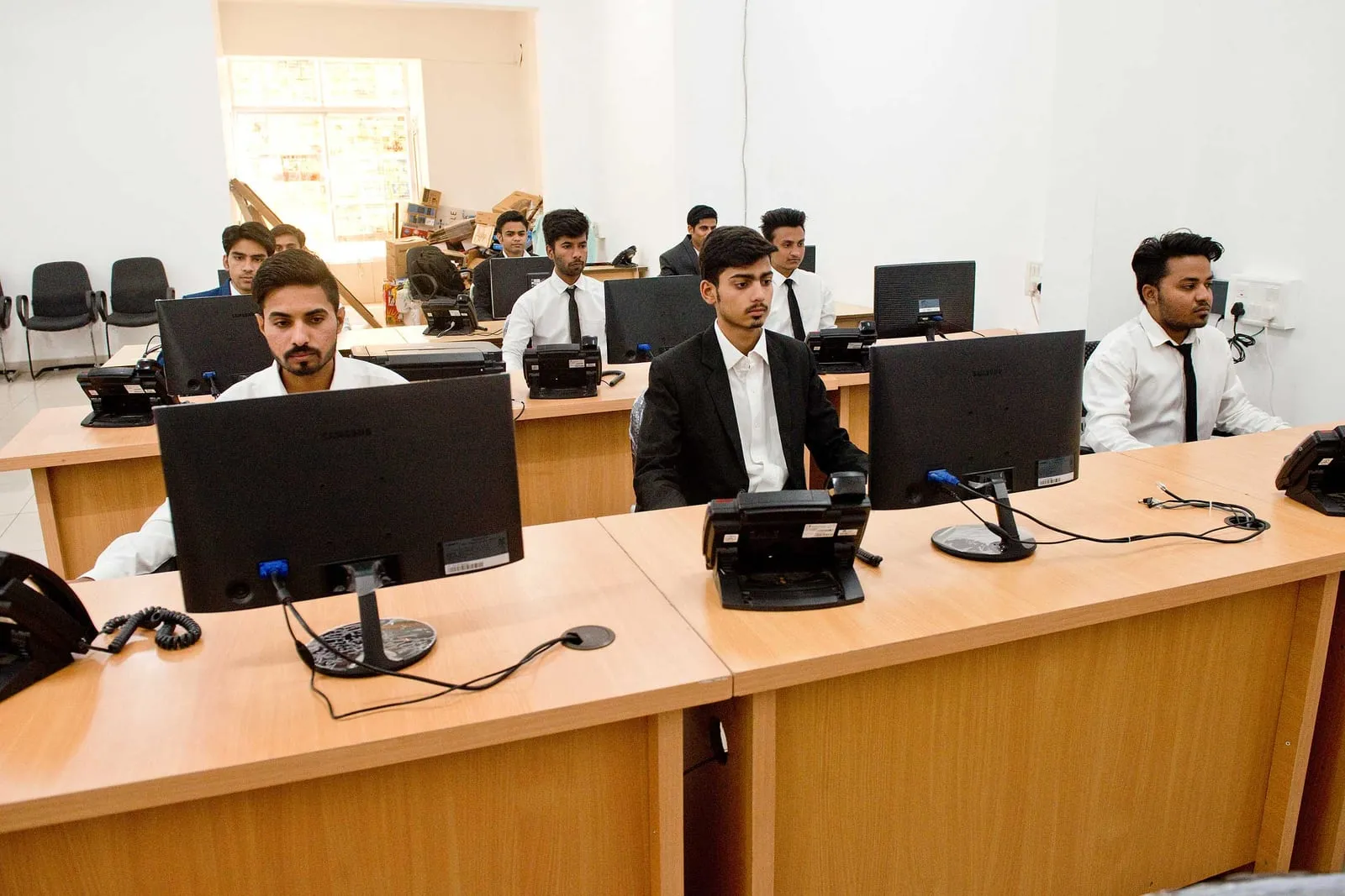 A row of SiOnline support staff working at desks